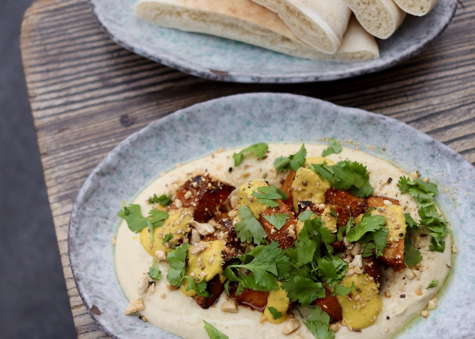 Hummus topped with roasted squash and amba