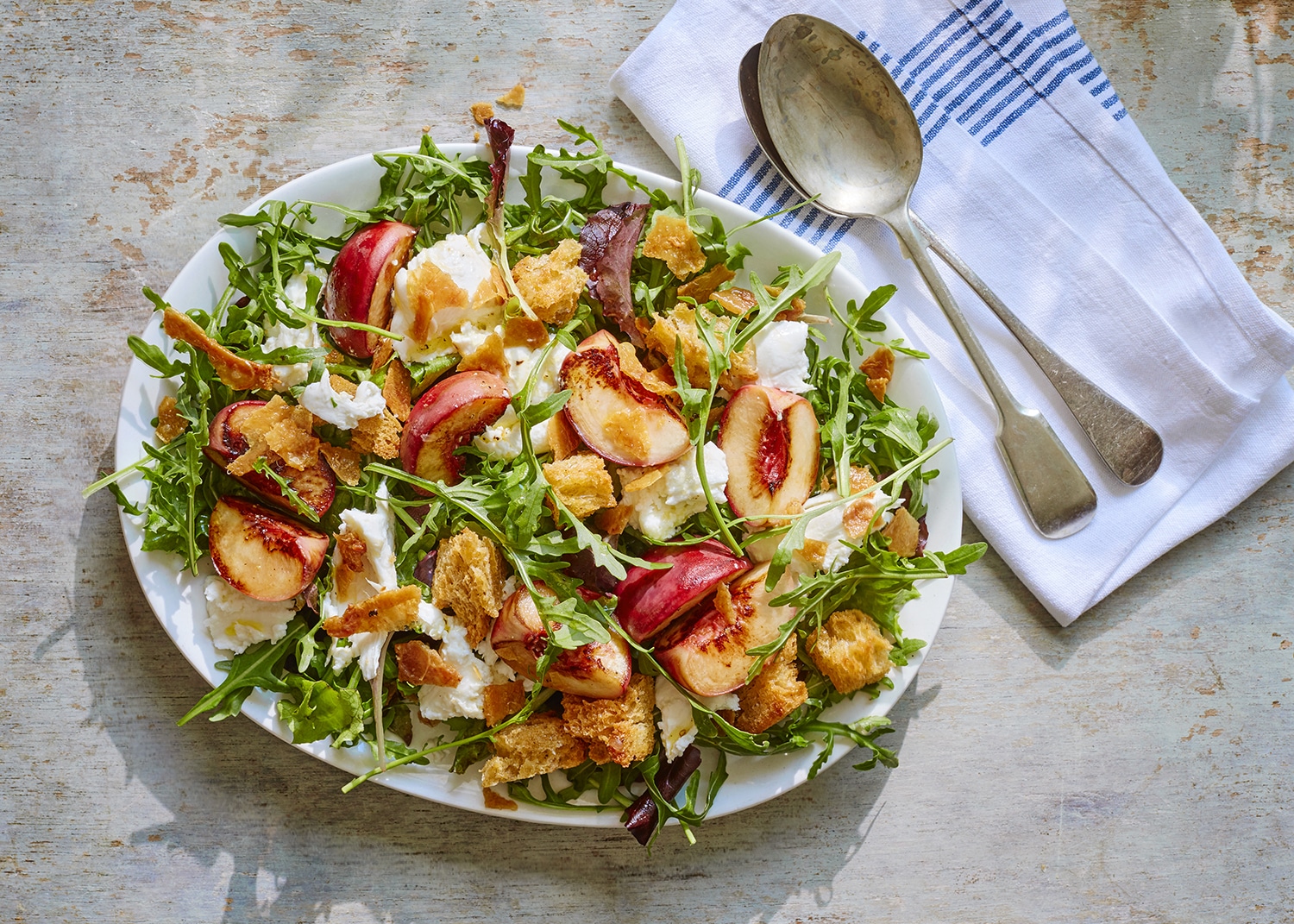 Crisped chicken skin with fried peaches, mozzarella and bitter leaves