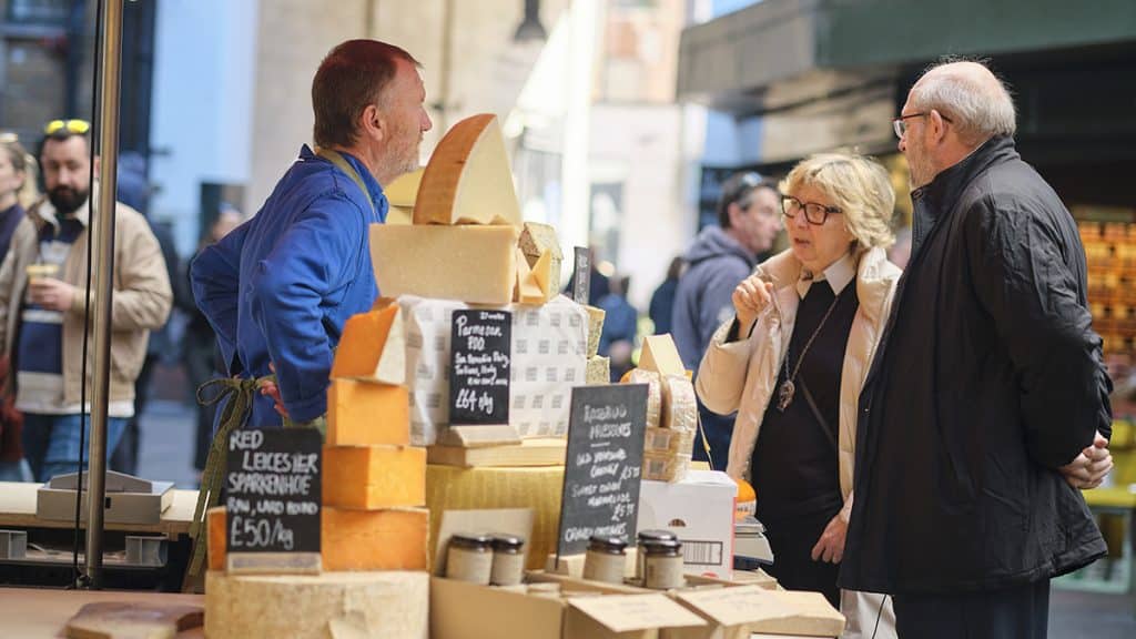 Shoppers talking to a cheesemonger at Borough Market
